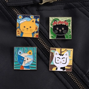 Detailed close-up of four artistic enamel cat brooches on a black leather jacket