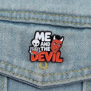 Macro detail of 'ME AND THE DEVIL' enamel pin badge attached to a denim jacket