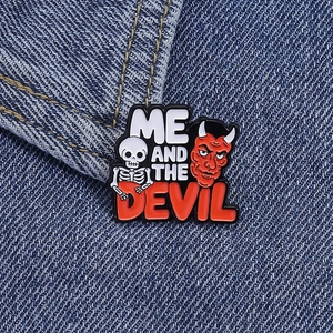 Detail of enamel skeleton pin with red devil and Me and the Devil text on denim