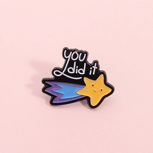 Cute yellow shooting star brooch with you did it text on a pink background