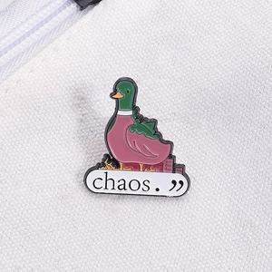 Detail of a cartoon mallard duck enamel pin with 'chaos' text on white canvas background
