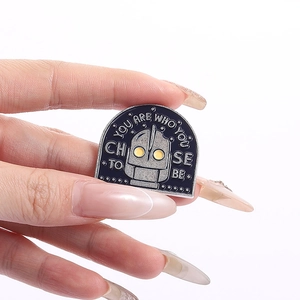 Detailed view of The Iron Giant enamel pin featuring You are who you choose to be quote