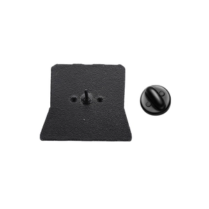Macro detail of black metal brooch back with sandblasted texture and rubber clutch