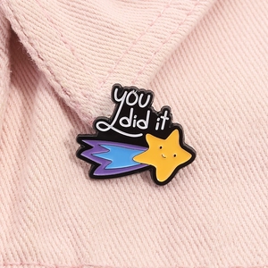 Cute yellow star enamel brooch with 'you did it' text on pink denim jacket background