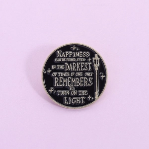 Macro shot of circular enamel lapel pin with lamp design on purple background