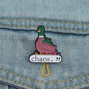 Detailed macro shot of creative chaos duck enamel pin on blue denim fabric background