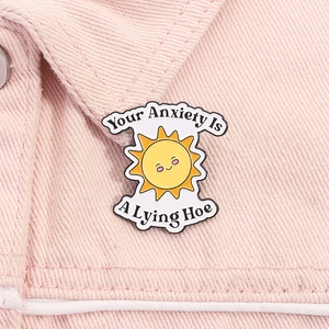 Detalle del pin de sol en tela vaquera rosa con texto Your Anxiety Is A Lying Hoe