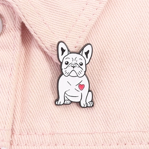 Dettaglio ravvicinato di una spilla in smalto bulldog bianco con cuore rosa su denim
