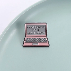 Close-up of pink enamel laptop pin featuring Document It Or It Didn't Happen slogan