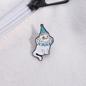 Détail d'une broche en émail chat clown blanc fixée sur un sac en toile de coton blanc