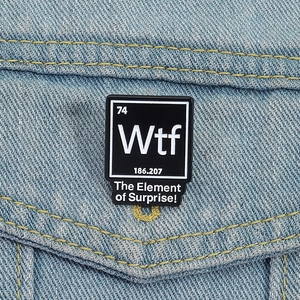Gros plan d'un pin's émaillé WTF tableau périodique sur une veste en jean bleu clair