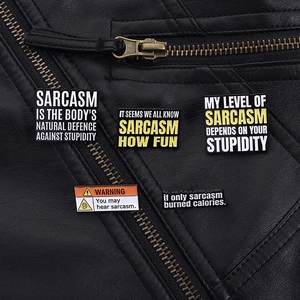 Detail of sarcastic quote enamel pins on a black leather jacket showing sharp punk style