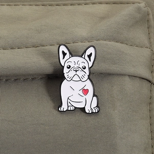 Vista macro di una spilla smaltata a forma di bulldog francese bianco con cuore rosso