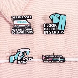 Detailed close-up of four medical enamel pins featuring an ambulance and doctor scrubs