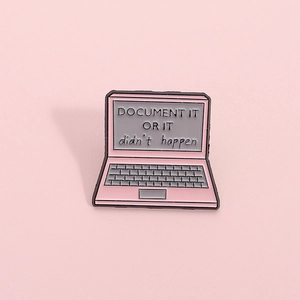 Pink laptop enamel pin with Document It Or It Didn't Happen quote on a matching pink backdrop
