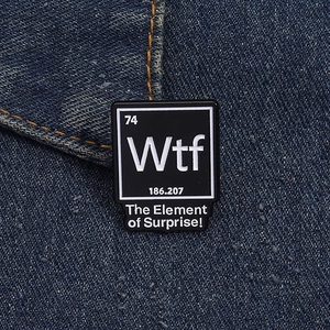 Détail de l'épinglette en émail du tableau périodique WTF sur fond de tissu denim bleu