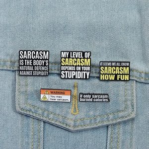 Set of sarcastic enamel pins with humorous quotes pinned on a blue denim jacket