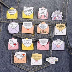 Détail de l'ensemble de broches enveloppes avec messages positifs sur une veste