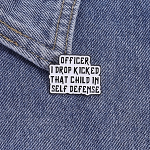 Officer I Drop Kicked That Child In Self Defense enamel pin on denim jacket