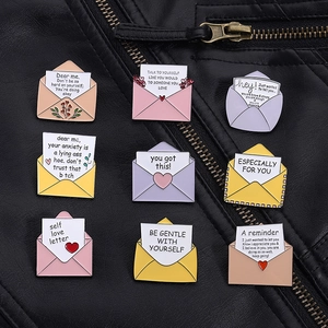 Détail macro de neuf badges émaillés colorés sur cuir noir avec des citations positives
