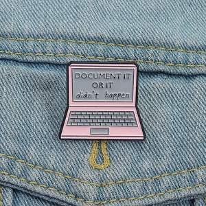 Pink laptop enamel brooch pin with Document It text on denim background fabric