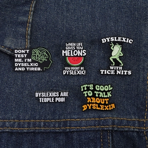 Detailed close-up of colorful enamel dyslexia awareness pins on blue denim fabric