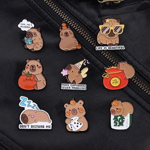 Détail de neuf épingles émaillées créatives en forme de capybara sur fond de cuir noir