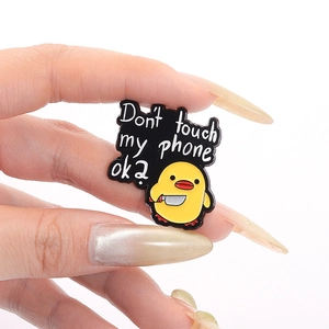 Funny cartoon yellow duck enamel pin with 'Don't touch my phone' quote on black background