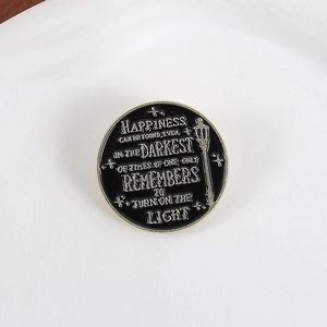 Detailed macro of enamel pin featuring happiness quote and street lamp on dark background