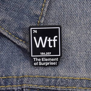 Broche en émail avec tableau périodique des éléments sur veste en jean bleu denim
