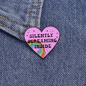 Silently Screaming Inside rainbow pink heart enamel pin badge on blue denim jacket