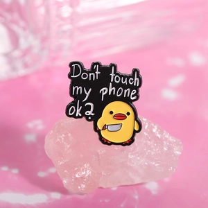 Detailed enamel pin with a yellow cartoon duck holding a knife and funny quote