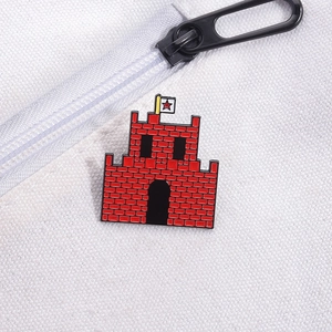 Detailed close-up of a red castle enamel pin with a star flag on white canvas bag