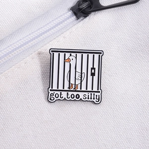 Detail of cute white goose enamel pin with got too silly text on a white canvas bag