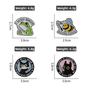 Detail view of cartoon enamel pins with dimensions and weights for frog and cat designs