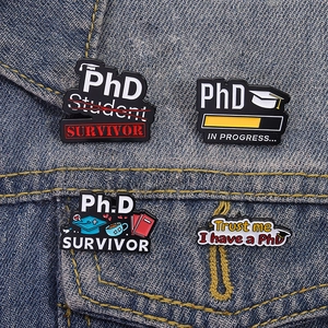 Lot de 4 épingles émaillées PhD sur denim, avec motifs de chapeau de diplômé et livres
