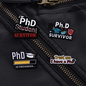 Gros plan détaillé des broches en émail PhD Survival et Progrès sur une veste en cuir