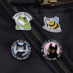 Detail of four funny animal enamel pins on a leather jacket with I ENJOY DANGER text