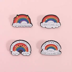 Set of four colorful rainbow enamel pins with creative English quotes on pink background
