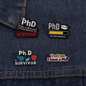 Vue détaillée de quatre pins en émail PhD avec symboles académiques sur denim bleu