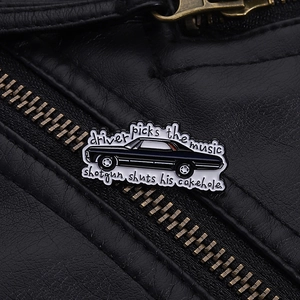 Detail of vintage enamel car pin with movie quotes on a black leather jacket