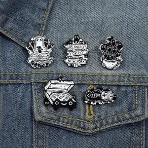 Detailed close-up of 5-piece cartoon cat enamel pins set on dark blue denim jacket pocket