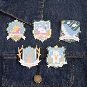 Set of 5 blue animal enamel pins including unicorn and rabbit on a denim jacket