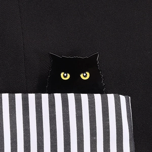 Gros plan sur l'épingle chat noir en émail avec yeux jaunes sur poche à rayures