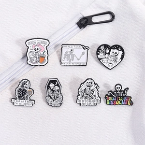 Detailed macro view of seven gothic skull enamel pins on a white canvas bag