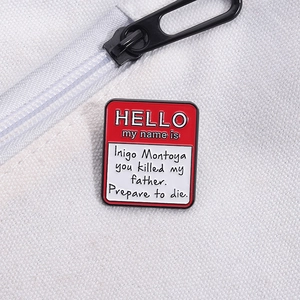 Close-up of Hello My Name Is Inigo Montoya movie quote enamel pin on white canvas