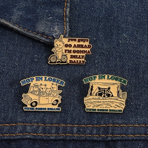 Detailed close-up of three enamel bear pins with humorous quotes on denim background