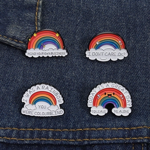 Macro shot of a four-piece rainbow enamel pin set on blue denim fabric background