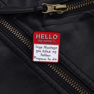 Detailed close-up of a name tag enamel pin on a black leather jacket with zipper details