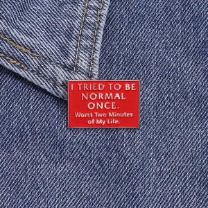 Red enamel brooch pin with humorous quote on denim fabric for clothing and backpacks